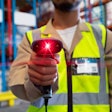 Mid section of mature Asian male worker showing barcode scanner